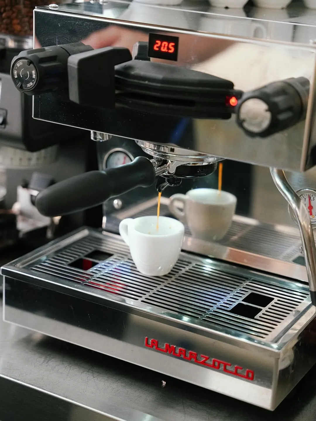 La cafetera sirviendo un café