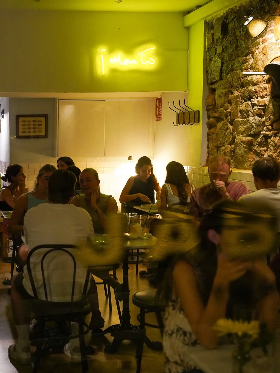 El comedor lleno bajo el neón amarillo de Jabato