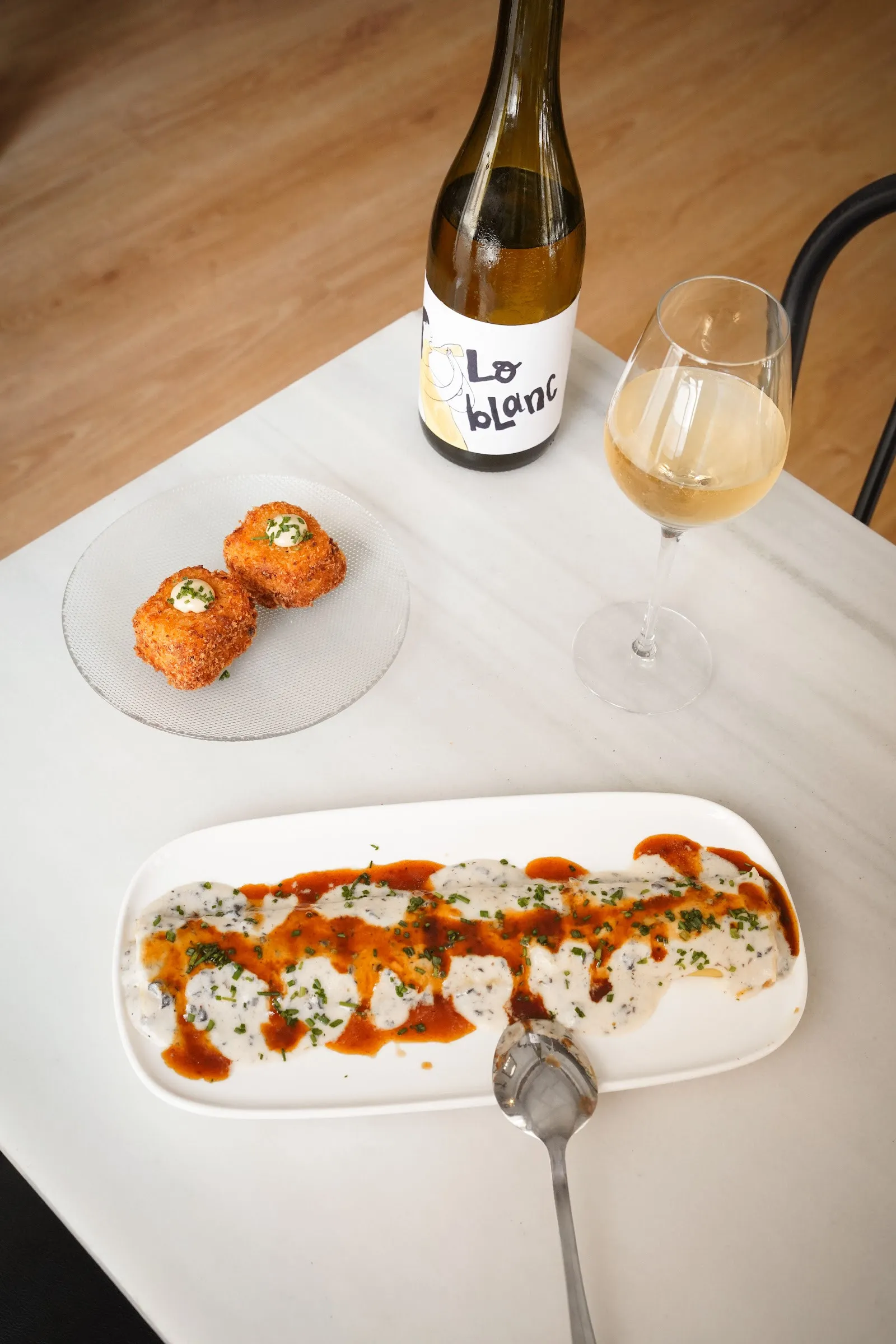 Vino blanco y tapas sobre la mesa de mármol